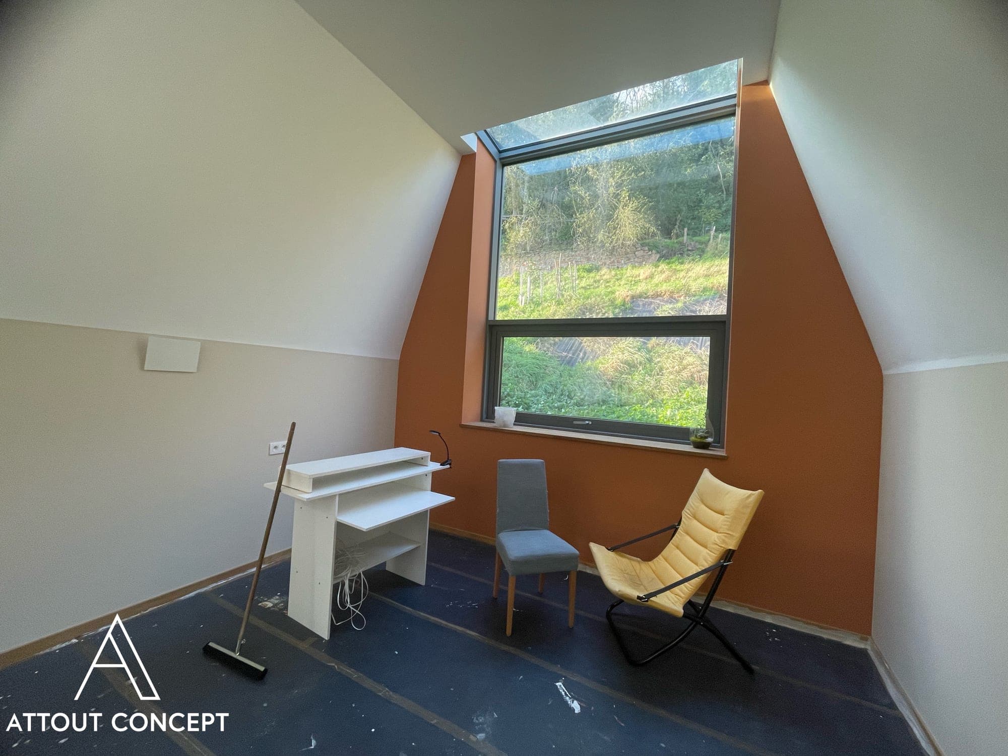 Combles aménagés avec mur d'accent terracotta et grande fenêtre de toit