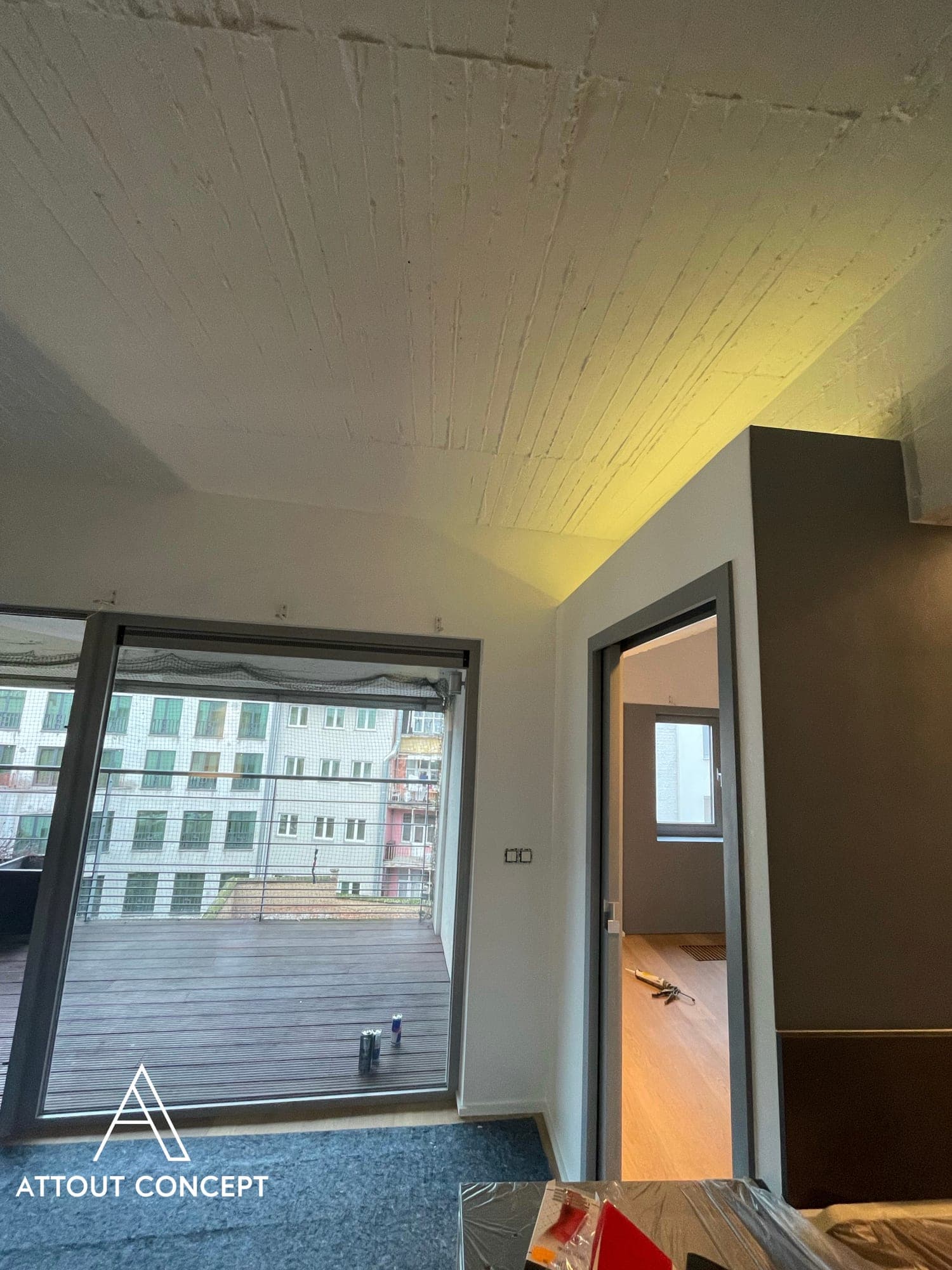 Baie vitrée vers la terrasse, plafond bois et murs fraîchement peints
